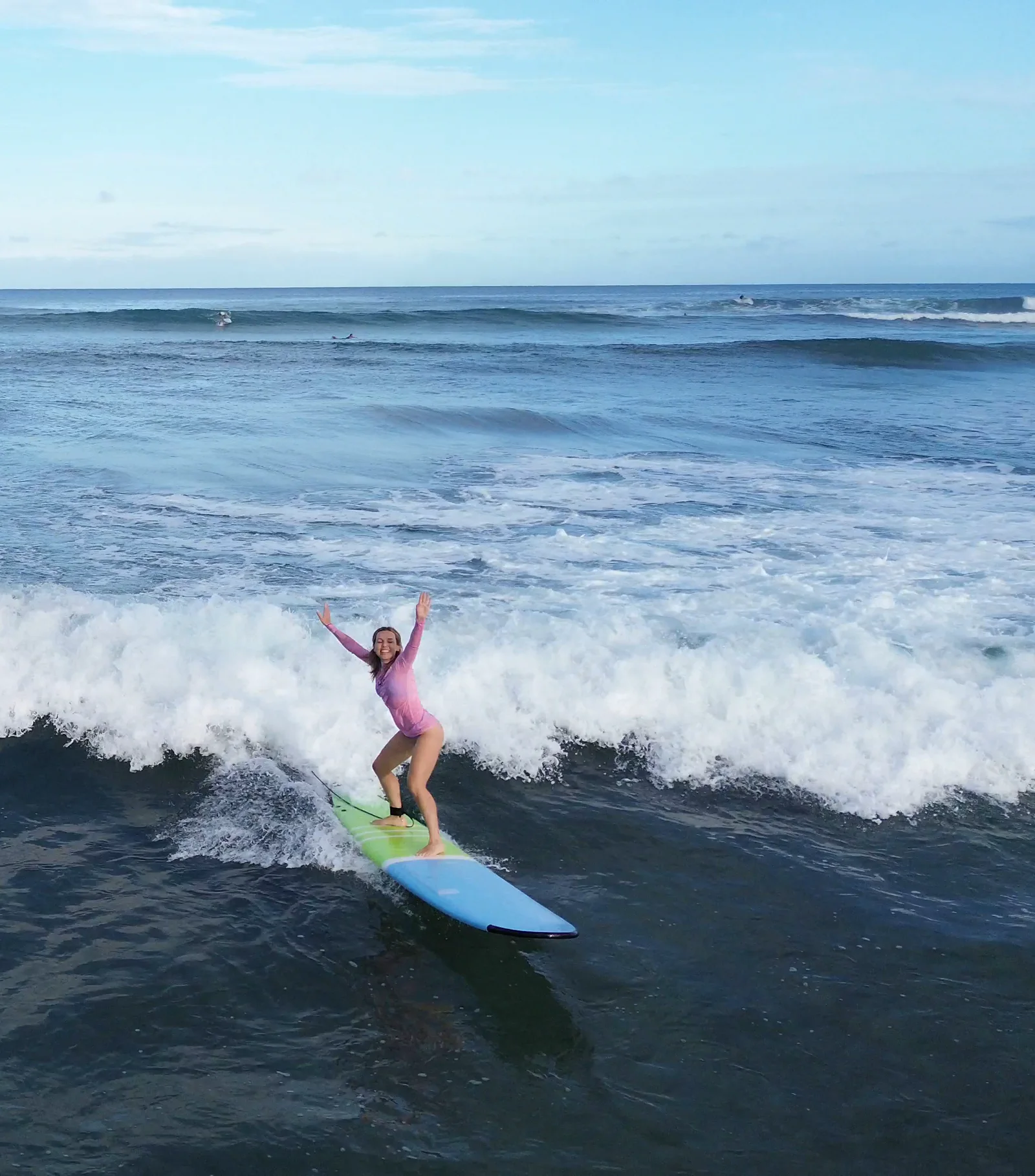 HI Surf Camp guest catching a wave in clear Hawaii water