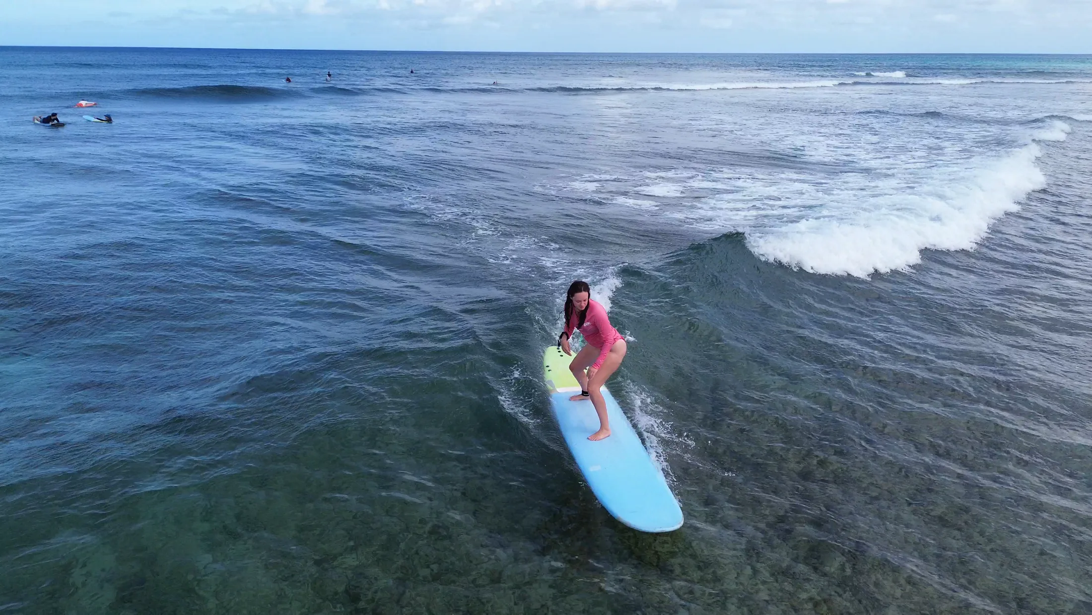 HI Surf Camp guest surfing in clear Hawaii water