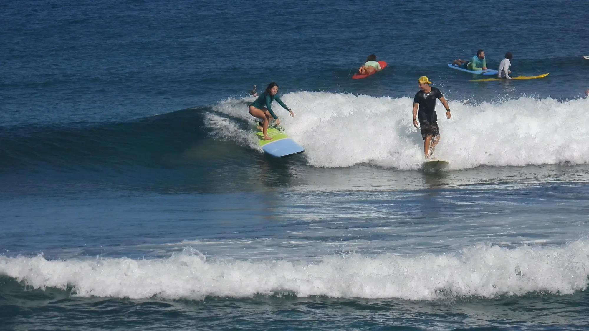 Daniel surfing beside a HI Surf Camp guest